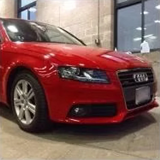 The same red sedan after repair, with the front end fully rebuilt