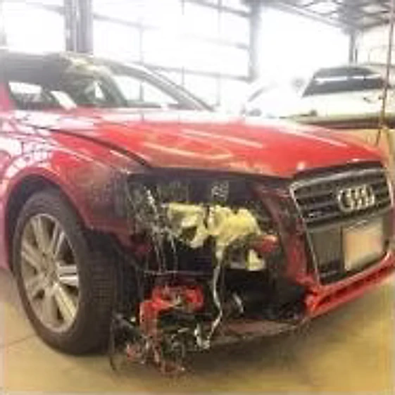 Red sedan with front-end damage, bumper and headlight assembly torn away