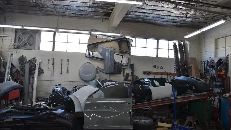 Replacement body panels, doors, and bumpers stocked inside Quincy Auto Body's collision repair shop